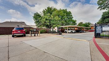 A parking lot with a red car and a white van.